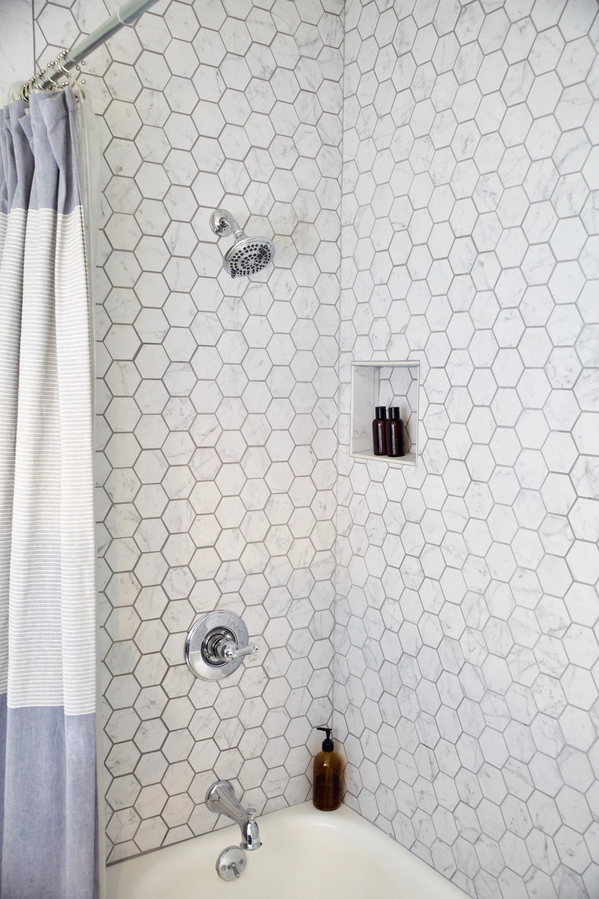 Atlas Concorde USA Eon Carrara Honeycomb Mosaic tile used as shower wall.