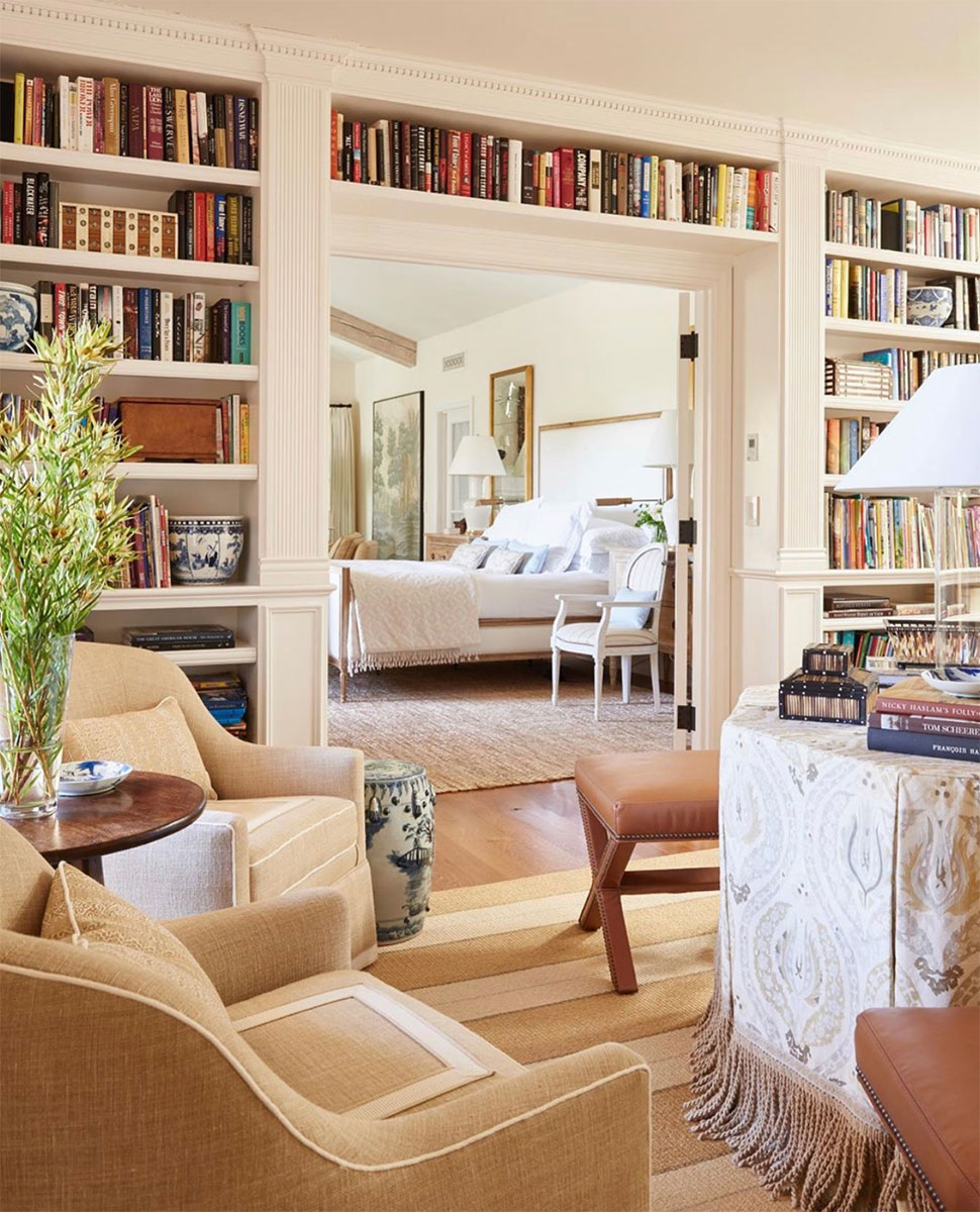 Encased door with wall of bookshelves featured in the Atlas Concorde USA blog by Mark D. Sikes Interiors